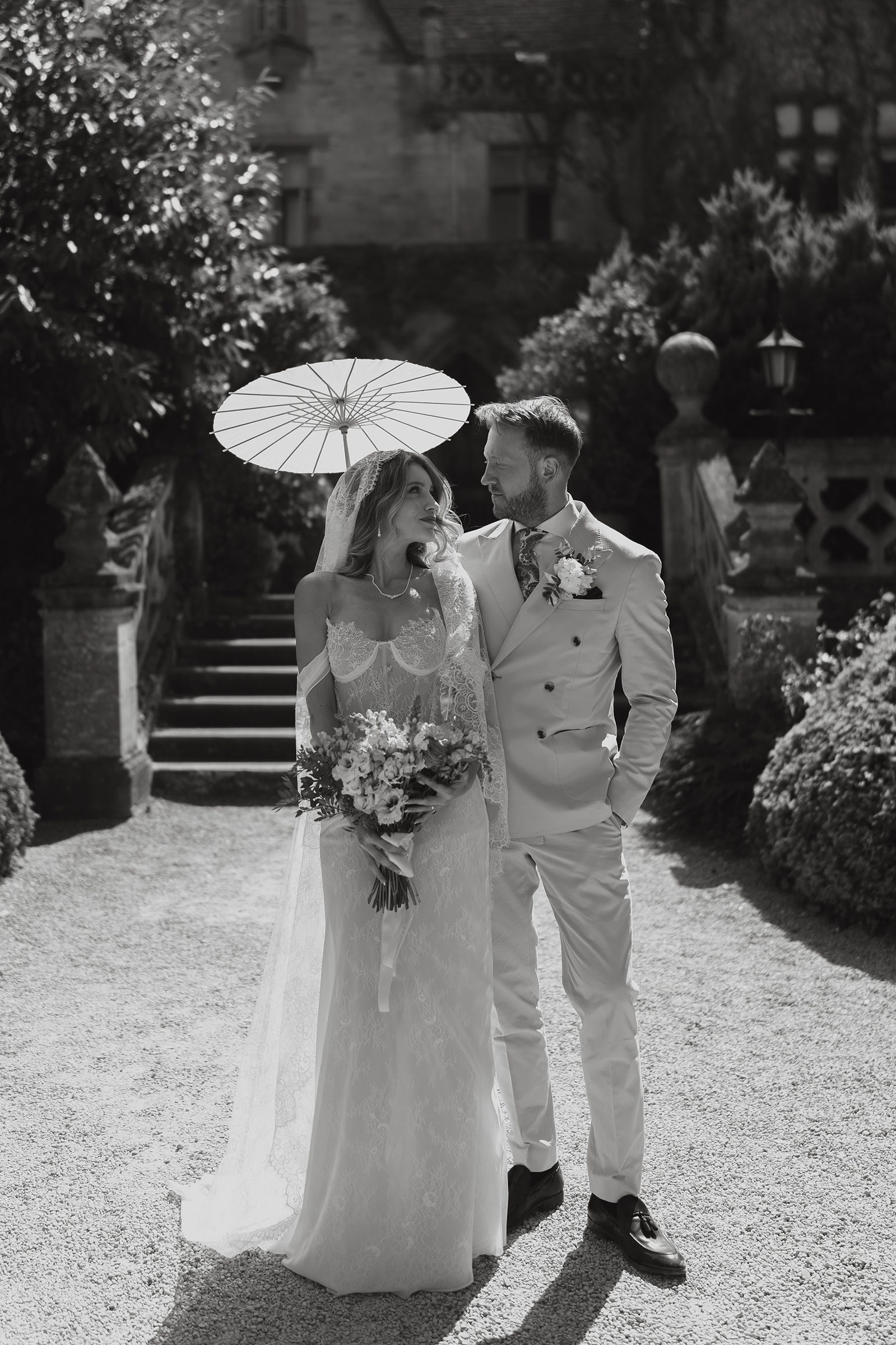 Black and white photo of Scott and Aura with a parasol outside Manor by the Lake, Cheltenham